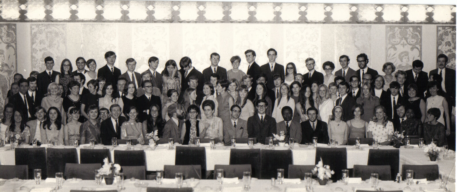 JYM Class photo, large group in a formal dining area posing for a picture 