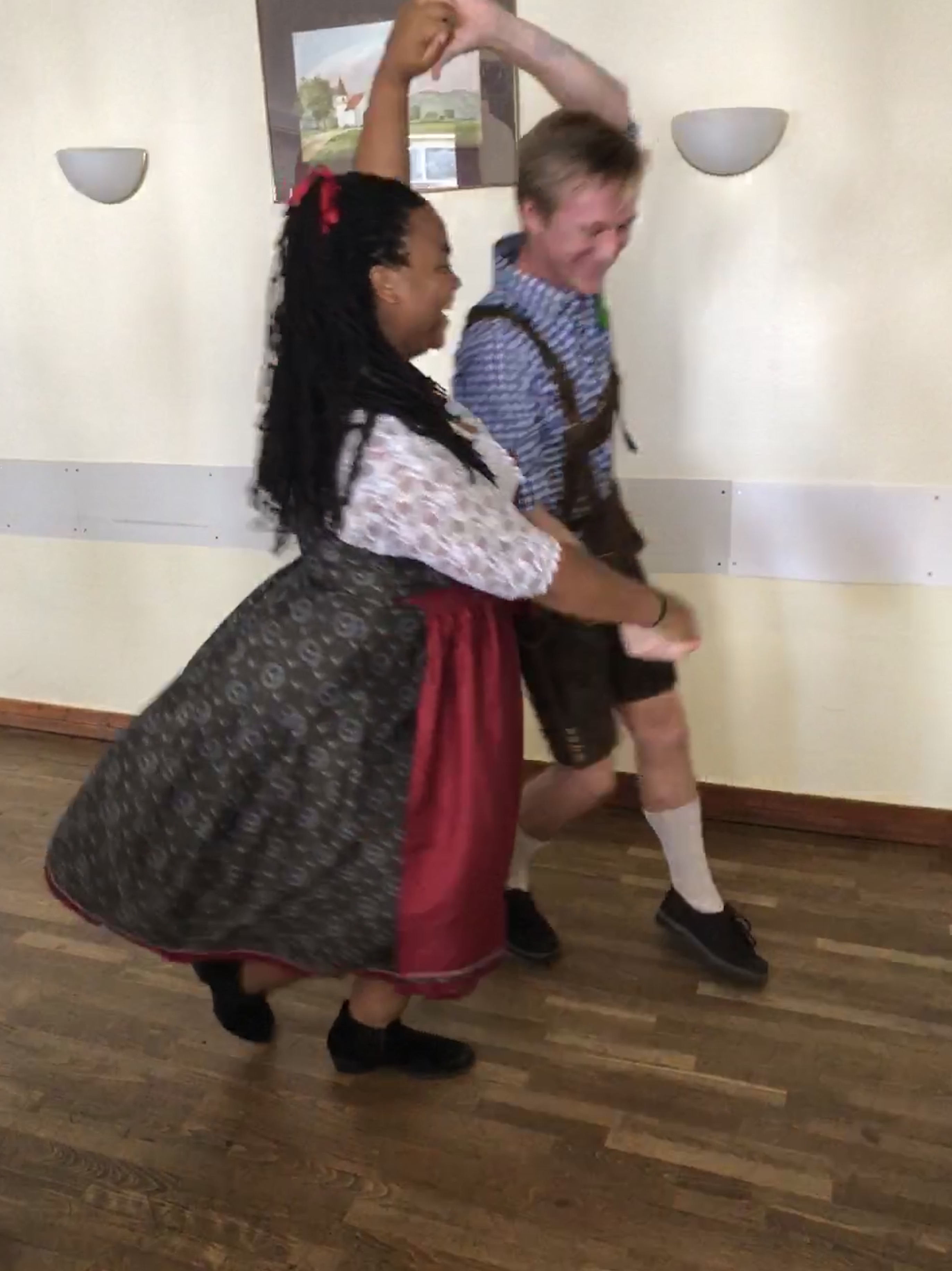 Lyric and Sam in traditional Bavarian outfits dancing